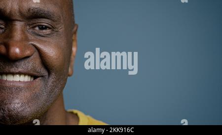 Close-up half male face with joyful expression mature african american man looking at camera smiling white healthy toothy smile happy customer Stock Photo