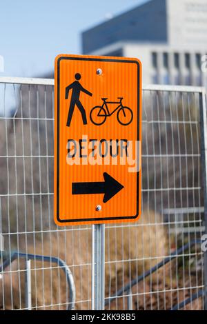 Orange detour sign for cyclists and pedestrians. Closed way for bikes and walking people. Stock Photo