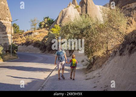 Father and son tourists on background of Unique geological formations in Love Valley in Cappadocia, popular travel destination in Turkey. Traveling Stock Photo