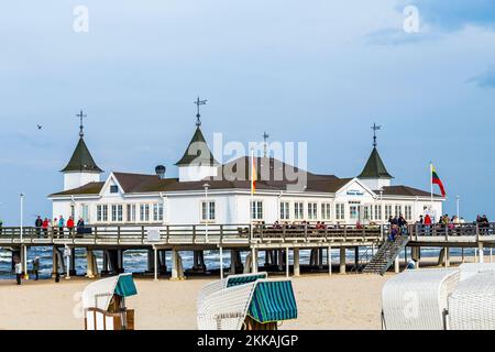 Ahlbeck, Germany - April 20, 2014: people enjoy pier and beach of Heringsdorf, Germany. The baltic Sea in Usedom Island is famous for its unique roofe Stock Photo