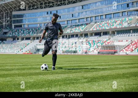 African American man playing football on the stadium field. Stock Photo