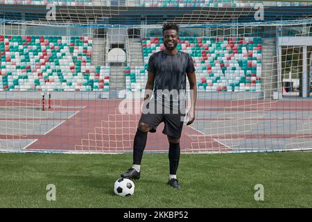 Man holding soccer ball with his foot in the stadium Stock Photo