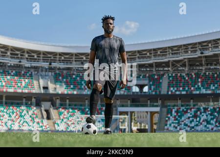 african american man holding a soccer ball in the stadium Stock Photo