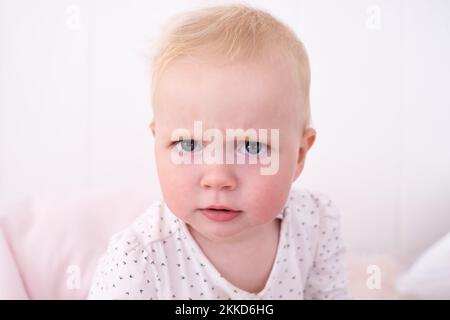 baby girl pouting frowning looking at camera seriously Stock Photo