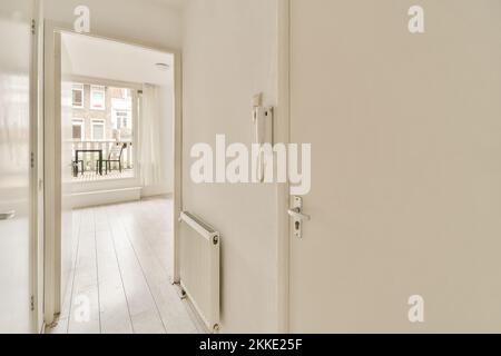 Interior of narrow corridor with telephone and radiator in daylight Stock Photo