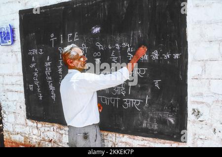 India, Agra - August 6, 1994: teacher teaches children in the outdoor classroom  in Agra, India. India  expands literacy to approximately two thirds o Stock Photo