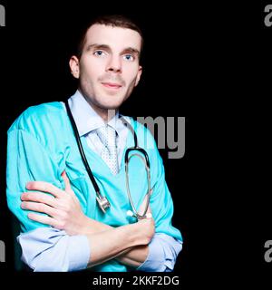 Handsome Male Doctor Standing Confidently With Arms Folded On Black Background Stock Photo