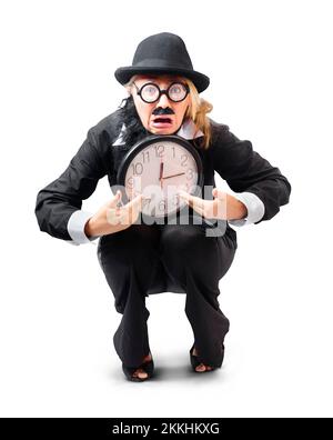 Businesswoman in black bowler hat and with fake mustache and beard looking distraught and crouching down holding large clock isolated on white backgro Stock Photo