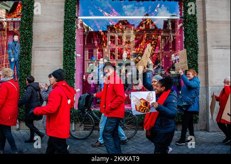 Amsterdam, Netherlands. 25th Nov, 2022. Protesters march with placards in front of the department store window during a strike on Black Friday. Employees of the Amsterdam branch of department store chain 'de Bijenkorf' took to the streets on strike during Black Friday. The employees have been on strike since the end of September demanding for appreciation, higher wages and justice. Several hundred of these workers are members of the Netherlands Trade Union Confederation (FNV), which was the one that announced the strike. Credit: SOPA Images Limited/Alamy Live News Stock Photo