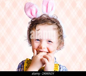 Child Eating Chocolate Easter Egg With Smile In A Easter Fun Concept On Copy Space Stock Photo