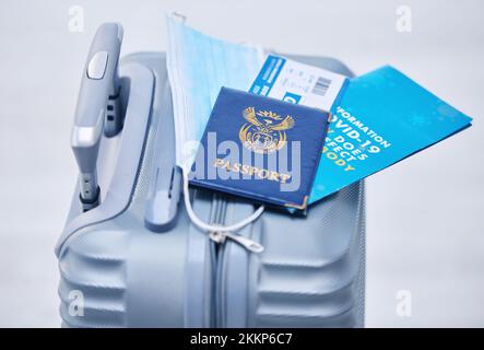 Covid, passport and suitcase for travel compliance, policy and documents in global, airport or visa information background. Corona, virus or covid 19 Stock Photo