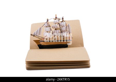 Old Ship on a notebook on a white background Stock Photo