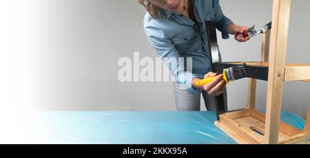Young women preparing to restore a stepladder for children as a hobby house improvement. On a covered table. Painting with brush. Banner with copy spa Stock Photo