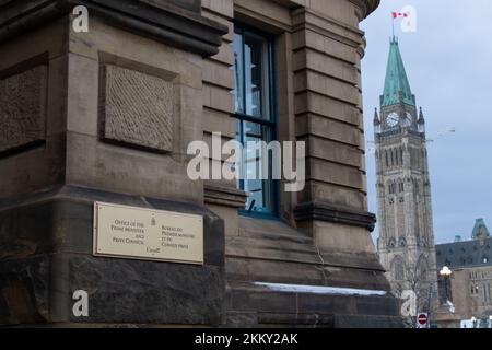 A sign for the Office of the Prime Minister and Privy Council is seen on a cloudy after in Ottawa, with the Parliament building seen in the background Stock Photo