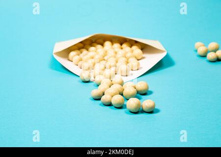 White chocolate balls on a blue background Stock Photo