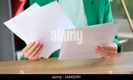 Woman holding financial documents with charts and graphs Stock Photo