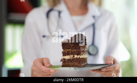 Woman nutritionist holding in hands piece of chocolate cake Stock Photo