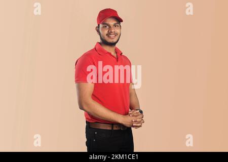 Confident young delivery man standing isolated on Color Background Stock Photo