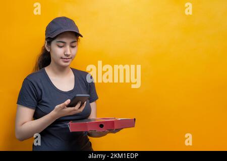 Cheerful pizza delivery Woman holding a smart phone Stock Photo