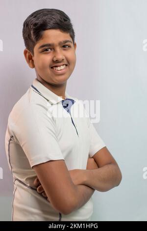 A boy in cricket uniform smiling and standing Stock Photo