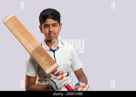 A boy in cricket uniform holding Cricket Bat Stock Photo