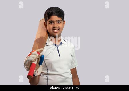 A boy in cricket uniform holding Cricket Bat Stock Photo