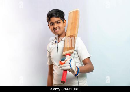A boy in cricket uniform holding Cricket Bat Stock Photo