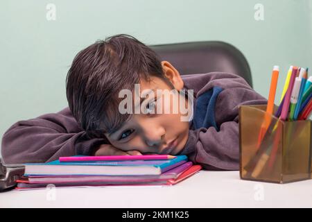 a boy laying down on table and looking at camera Stock Photo