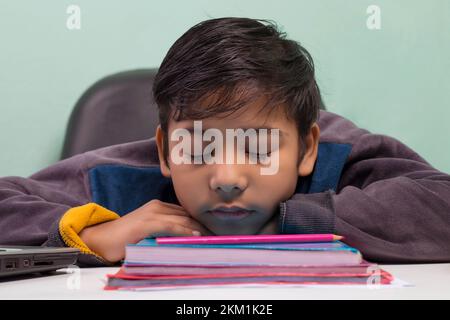 a boy laying down on table and Sleeping Stock Photo