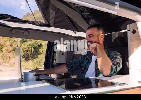 man working on his laptop from his camper van Stock Photo