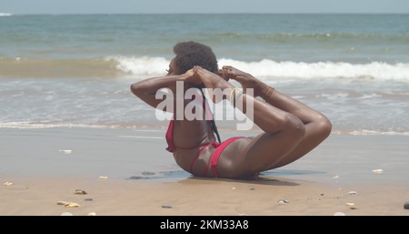 Amazing contortionist flexibility by a young girl in a bikini at the beach