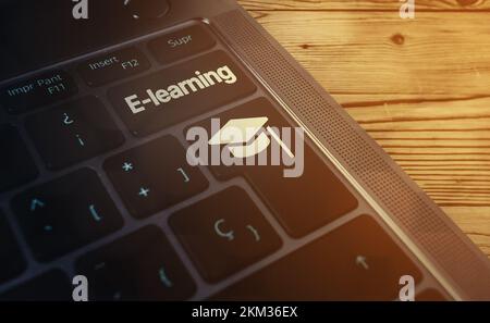 Laptop keyboard with E-learning word on button and graduation cap. Webinar. Online education. Distance courses. Stock Photo