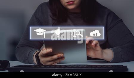Woman searching on tablet for online education with icons interface. Webinar online. E-learning. Distance courses. Stock Photo