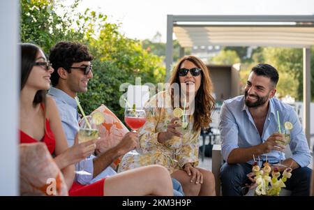 Business cocktail party with colleagues, millennials people having fun at celebration party, summer gathering with friends, handsome and elegant peopl Stock Photo