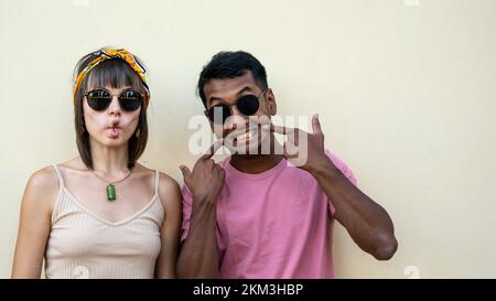 young lovely woman and funny man making face looking at the camera, two friends having fun grimacing Stock Photo
