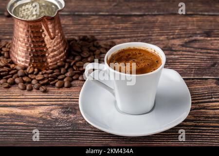 Turkish coffee in classic coffee cup with water and Turkish delight on wooden table Stock Photo