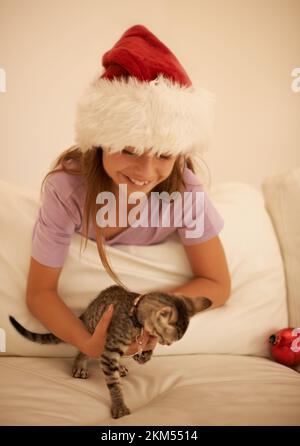 Christmas, child and cat kitten for present or gift of love for happiness, care and holiday celebration in family home. Smile of girl excited and