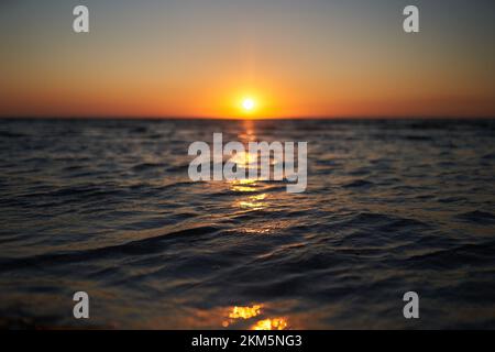 The golden sunrise above sea waves. Sunset above ocean. Soft focus on water. Stock Photo