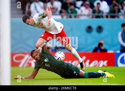 Poland's Robert Lewandowski (top) and Saudi Arabia's Ali Al-Bulaihi battle for the ball during the FIFA World Cup Group C match at the Education City Stadium in Doha, Qatar. Picture date: Saturday November 26, 2022. Stock Photo