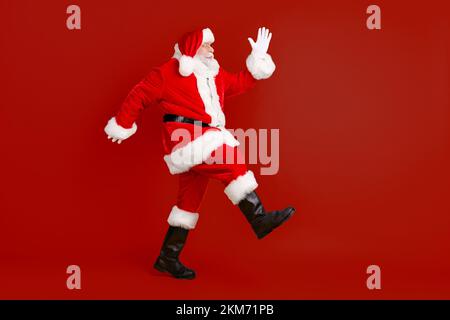 Full length body size profile side view of his he nice funny thick elderly white-haired Santa St Nicholas going having fun making step sale isolated Stock Photo