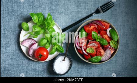 Juicy salad with tomatoes, basil and blue onion. Stock Photo
