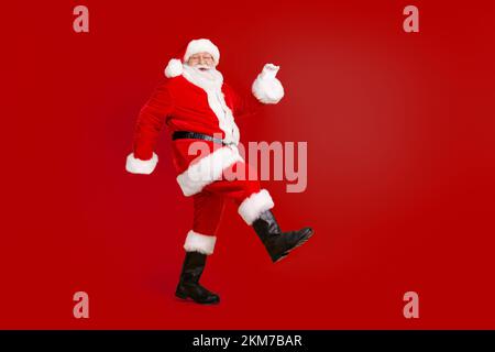 Full length body size view of his he nice funny cheerful cheery thick white-haired Santa St Nicholas walking having fun isolated bright vivid shine Stock Photo