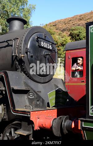 A female passenger on an adjacent train admiring the smokebox of BR Standard class 4 tank engine No 80136 at Goathland station, NYMR. Stock Photo
