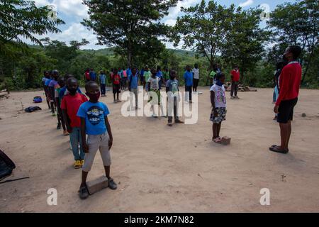 Primary students lining up to sing the national anthem in the school yard before the lesson begins Stock Photo