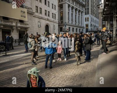 Tourists flock to the bronze statue, 'The Fearless Girl' by the artist Kristen Visbal in front of the New York Stock Exchange on Tuesday, November 22, 2022. (© Richard B. Levine) Stock Photo