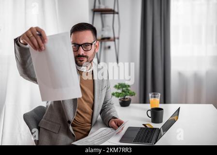 Handsome bearded adult man, checking the numbers his business is making. Stock Photo