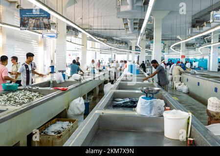 MUTRAH, OMAN - NOVEMBER 14, 2022: Vendors selling tuna, sardines and other fish species at fish souk in Mutrah. Oman. Stock Photo