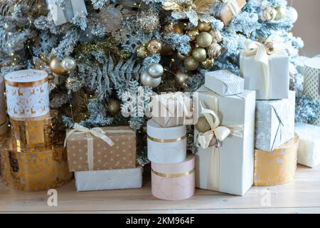 Christmas presents under the Christmas tree. New Year's and Christmas. Wrapped Gift. Beautiful packaging. Ribbon and bow on the packaging. Stock Photo