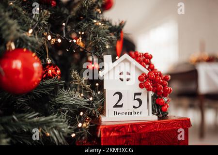 Merry christmas day 25 december eve event fairytale vibes. Sparkling bokeh garland shiny glister twinkle lights Noel tree decorations wooden cube cale Stock Photo