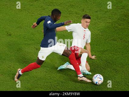 France's Ousmane Dembele (left) and Denmark's Joakim Maehle battle for the ball during the FIFA World Cup Group D match at Stadium 974 in Doha, Qatar. Picture date: Saturday November 26, 2022. Stock Photo